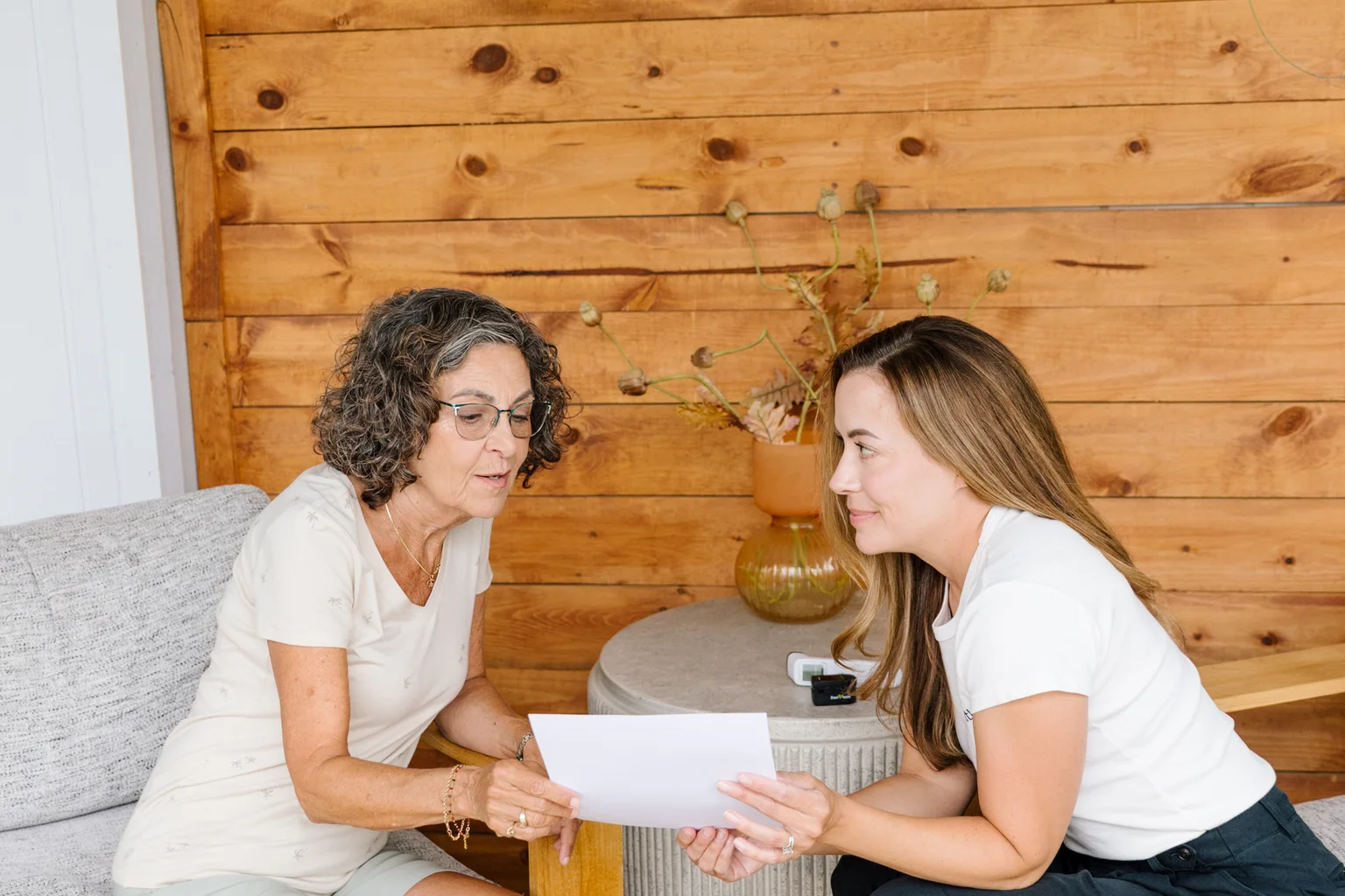 Registered nurse going over a written dementia care plan with a client in her living room