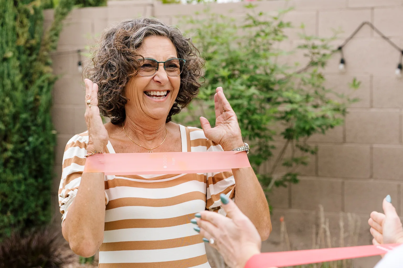 Older adult working through a guided resistance band exercise with a registered nurse at home