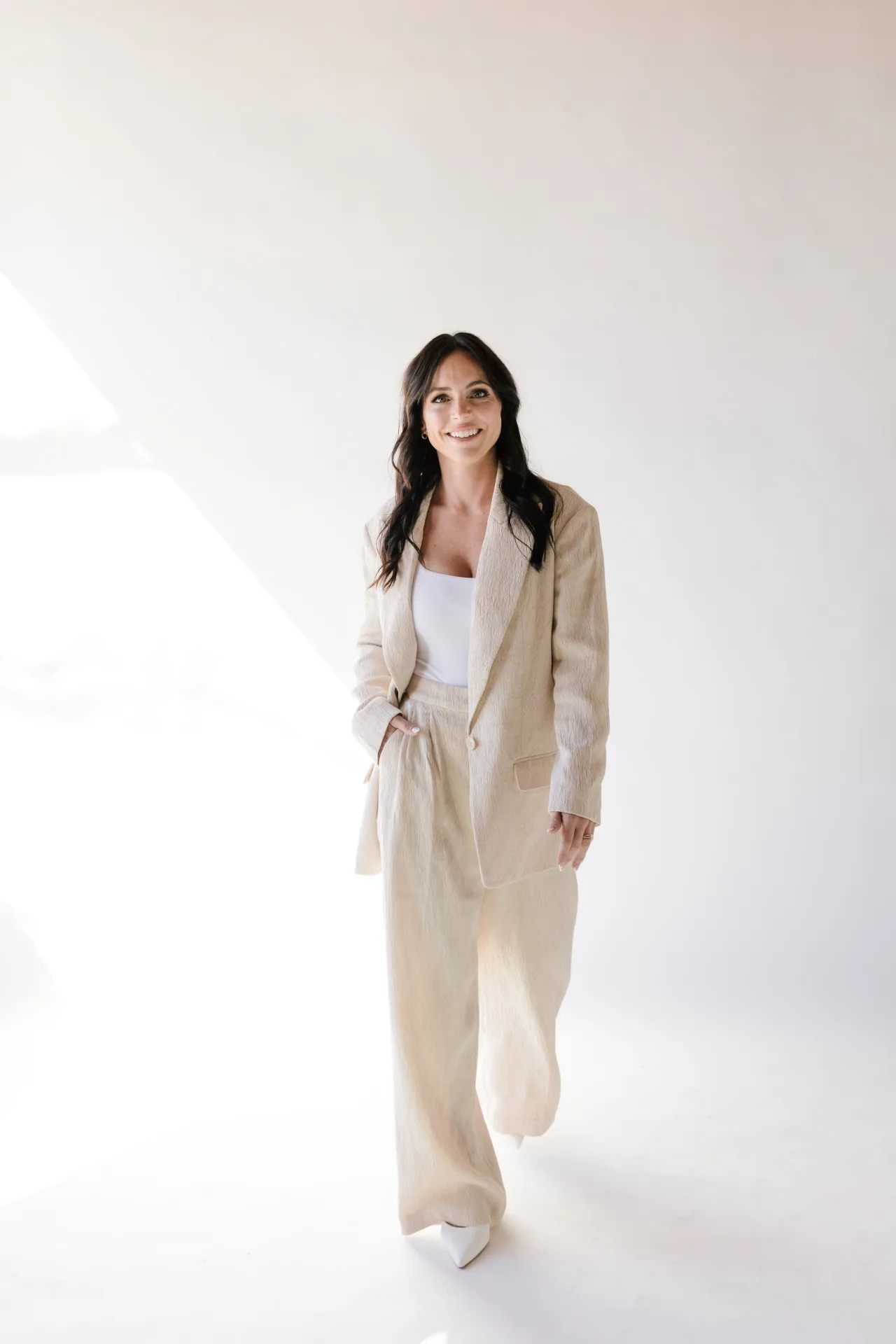 Founder Bianca Fabbo, RN, walking confidently in a bright studio